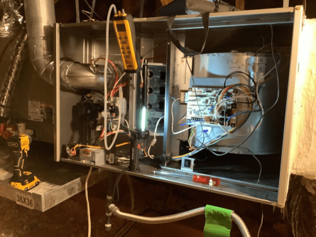 An open furnace cabinet showing the control board and wiring during a Colony heating service call in Little Elm