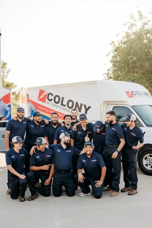 A group picture of Colony’s technicians posed in front of a Colony service truck.